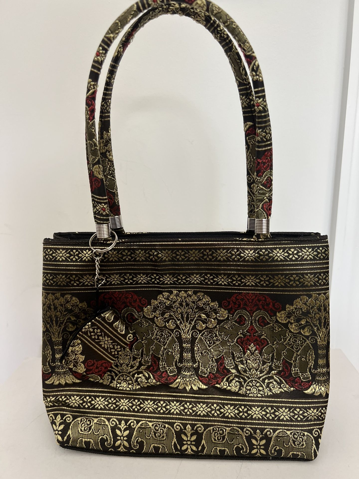 New colorful small fabric handbag with elephants purchased in Thailand. Colors include black, gold and an orangey-red. Purse has 2 zippered pockets. B