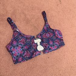 Soft crop top with vibrant floral print. Two front rings add a bold accent. Adjustable shoulder straps for a custom fit. Stretch fabric for comfort du