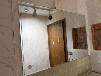 large, frameless rectangular wall mirror mounted 48 by 30