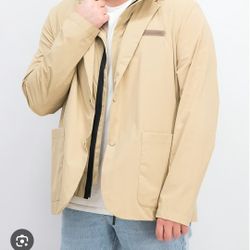 Lacoste beige rain jacket. Slit on the back. Front closure with press studs. Two patch pockets on the front. Sleeveless hooded jacket inside can be wo