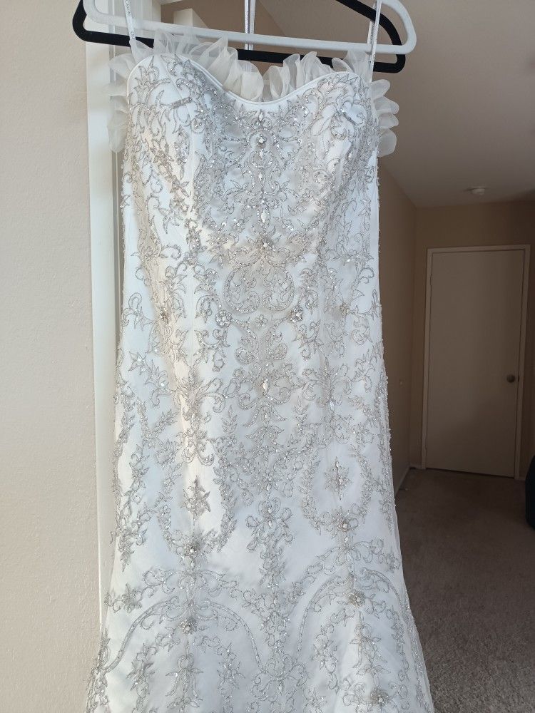 Oleg Cassini White bead embroidered wedding dress Size 10 Ivory mermaid style with a sweetheart neckline

Condition is used with a couple small tears 