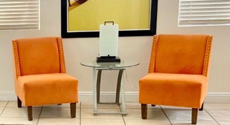 A pair of accent chairs and glass top table