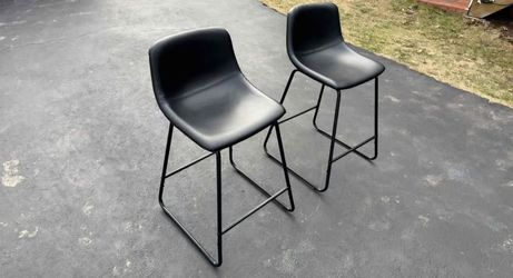 Centiar bar stool in black faux leather with a tubular metal base and bucket-style seat.