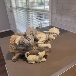 Sculpture of a Boy playing on log with dog Designed/Sculpted by Jaimy
