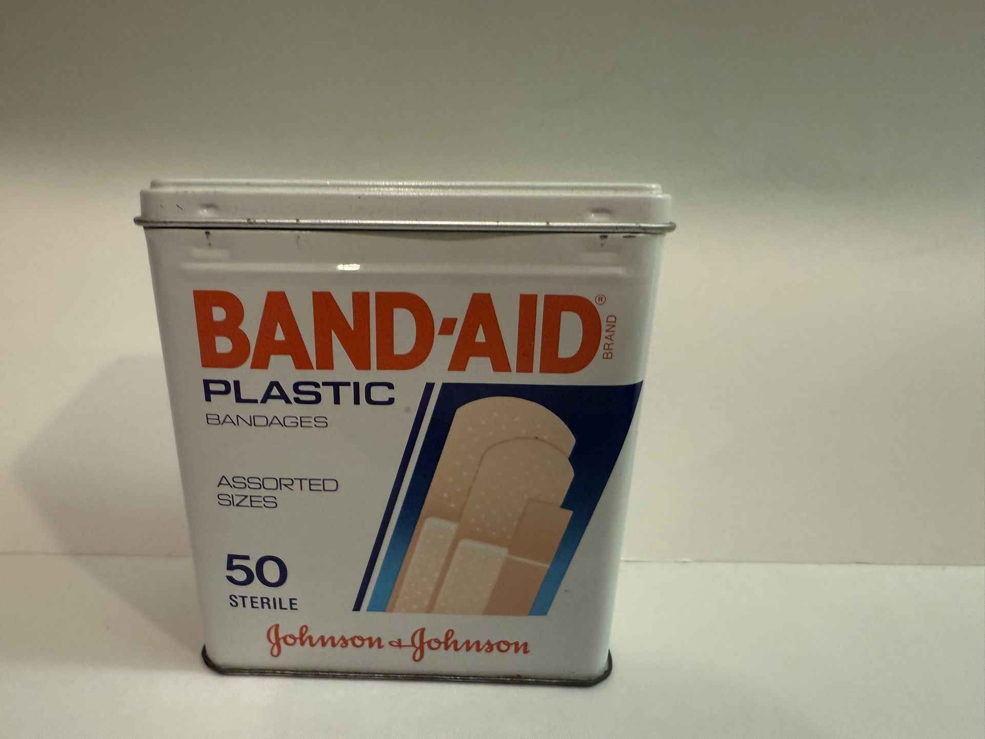 vintage tin of Band-Aid Plastic Bandages by Johnson & Johnson. The tin contains 50 sterile bandages of assorted sizes.