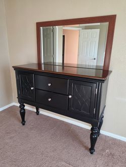This classic black and cherry-wood-toned sideboard server features an intricate geometric cabinet do