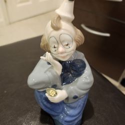 PAUL SEBASTIAN PORCELAIN SEATED CLOWN FIGURINE HOLDING A YELLOW FLOWER