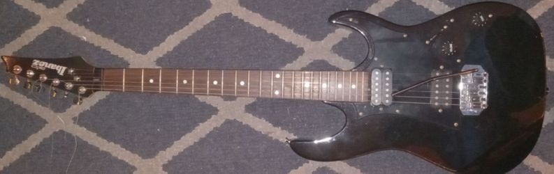 Ibanez GIO electric guitar in black features a double-cutaway RG-style body and dual humbucking pickups.