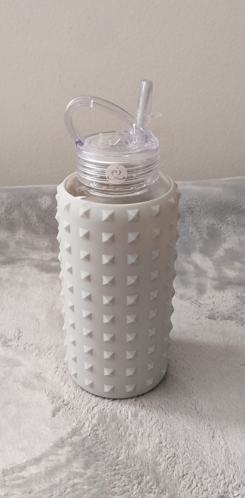 Apana 20oz Clear Water Glass Bottle with a Gray Spiked Silicone Sleeve