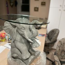 Oval Glass Top Side Table With A Baby Elephant Sitting Up