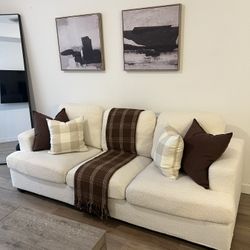 Beige 3 seater couch with decorative pillows and throw blanket included