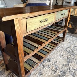 Design by Ashley Mestler rustic brown sofa table with multicolored shelves.