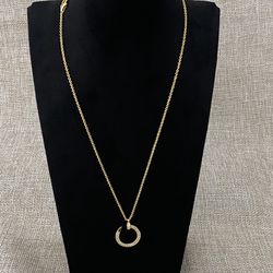 Cartier's Classic Gold Nail Pendant Necklace With Diamonds Set Around The Edge. 