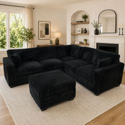 Black jumbo corduroy sectional sofa with ottoman