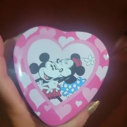 special edition Disney Mickey & Minnie "Kissing Time" watch in its original heart-shaped collector's tin. 
The watch features Mickey and Minnie on the
