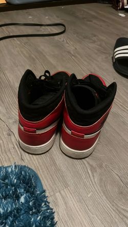 Nike Air Jordan 1 Mid SE "Christmas" sneakers in red and black.