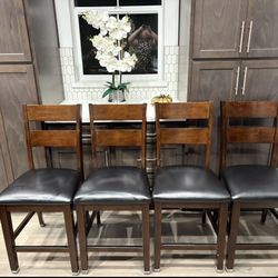 4-piece set of 24-inch solid wood barstools with leather seats, in good condition and very comfortable.