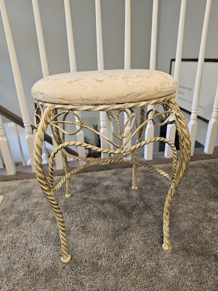 vintage-style vanity stool with a decorative metal base 