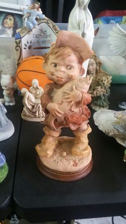 Fisherman kid holding a fish statue