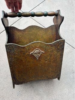 Magazine rack, antique with sculpture on it Magazine rack, antique with sculpture on it