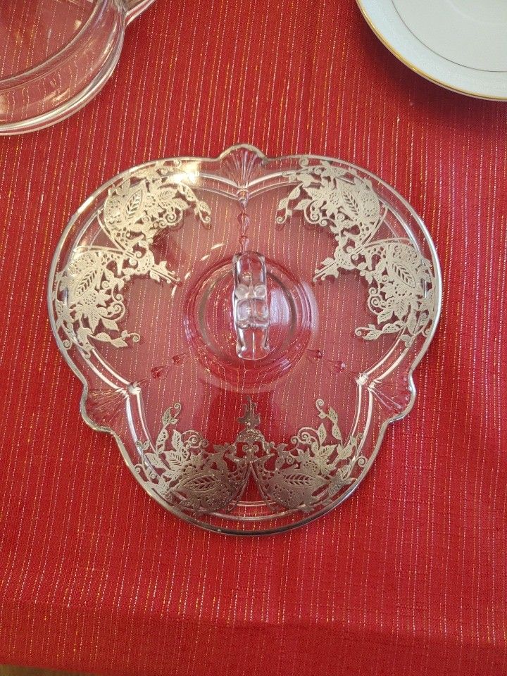vintage glass serving tray with a silver overlay floral design and a center handle. 