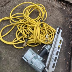 Nail Gun With The Air Compressor Hose 