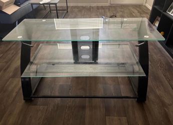 Modern glass TV stand in excellent condition. Features a sleek, contemporary design with three spacious glass shelves