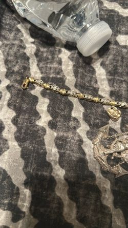 Tennis bracelet and gold tooth & crucifix on an anchor