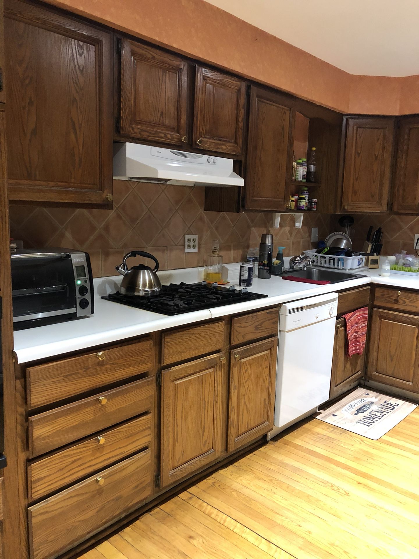 Kitchen Cabinets, oven, microwave, dishwasher, gas stovetop, and hood range