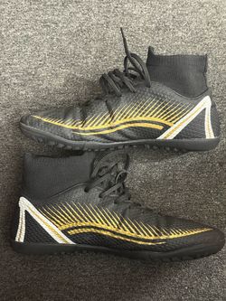 Gold and Black turf cleats