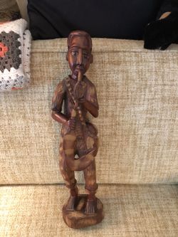 Jamaican Hand Carved Statue of a Man Holding a Pipe and Sickle, Created from a Solid Piece of Mahogany. 