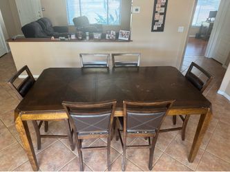 Tall brown dining room table and chairs set