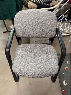 chair featuring a gray patterned fabric and a black metal https://offerup.co/faYXKzQFnY?$deeplink_path=/redirect/: The chair includes fixed black armr