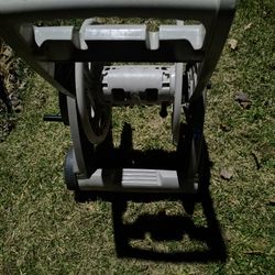 Tall, heavy , sturdy, tan Rubbermaid like real hose with wheels.. one wheel missing. Don't seem to need .