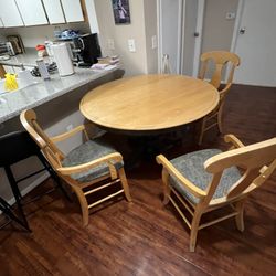 circular wooden table with 4 chairs