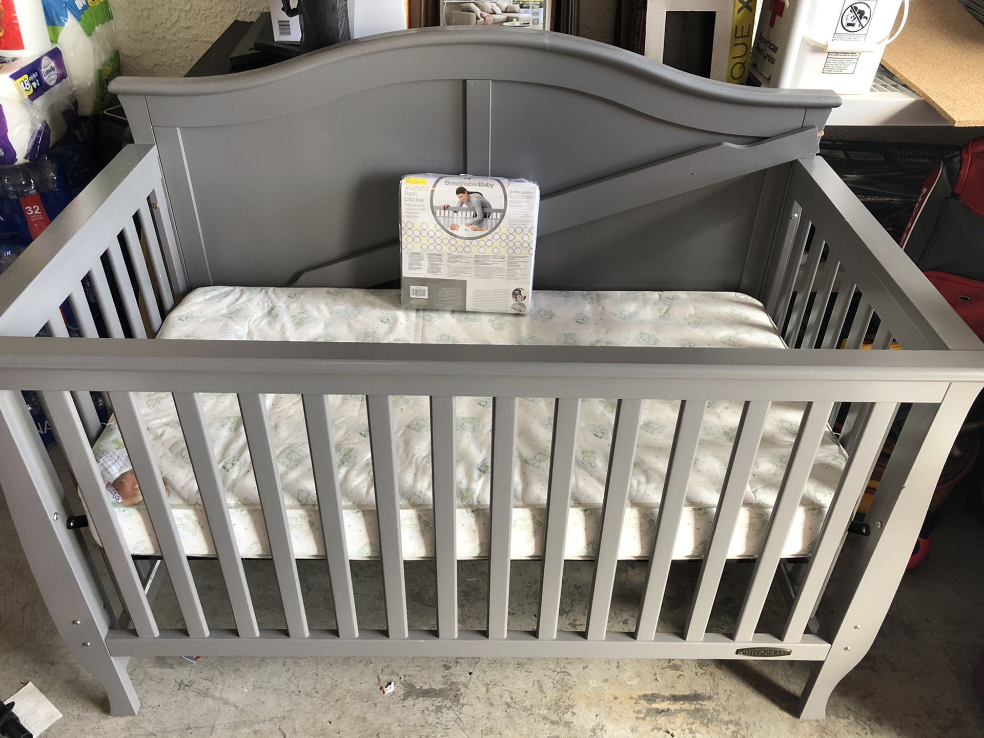 Gray baby crib with mattress
