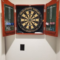 Dart board in oak cabinet