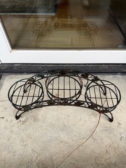 arched metal plant stand with three circular pot holders