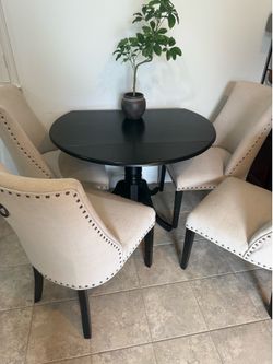Round dining room table with drop leafs and four chairs
