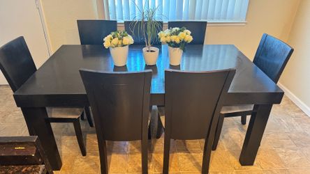 Sturdy wood dining set in a dark espresso finish. This set includes a rectangular table with thick block legs and seven matching high-back chairs with