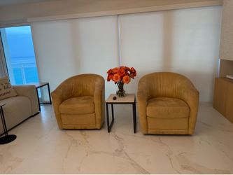 Two Natuzzi barrel swivel chairs