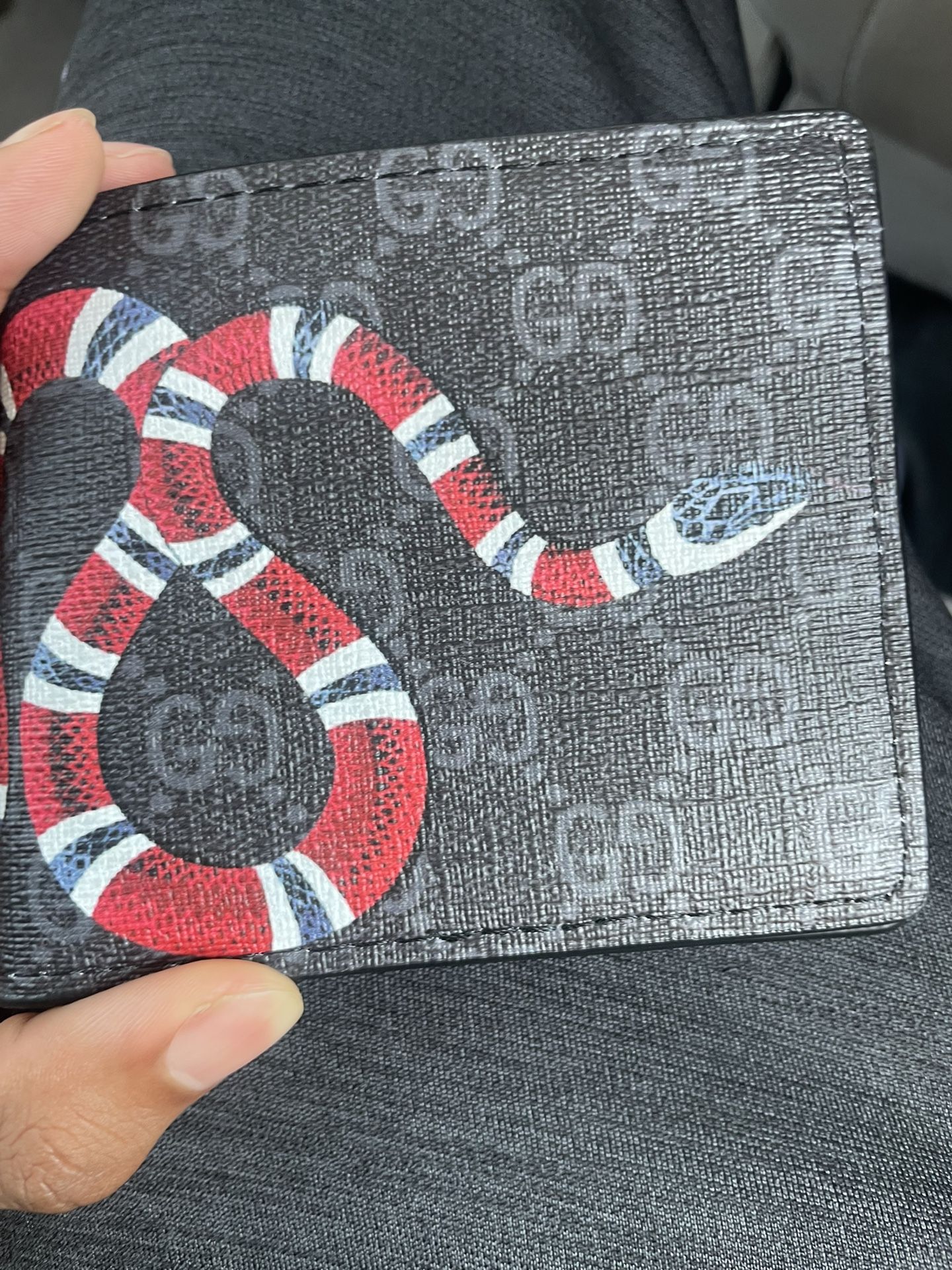 Gucci Kingsnake Wallet iconic Kingsnake print on a background of black GG supreme canvas. 