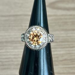 This stunning ring features a vibrant orange gemstone set in a gold-toned band. Perfect for adding a touch of elegance to any outfit.