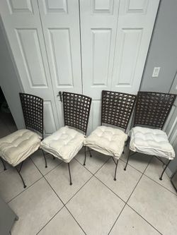 vintage mid-century modern wrought iron dining chairs with cane/wicker backrests.