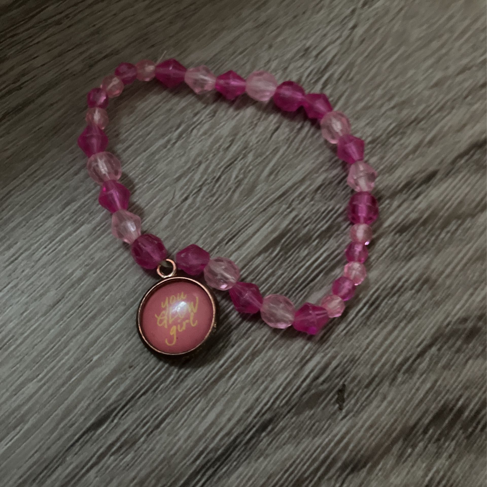 White and dark pink bracelet with charm that says you glow girl