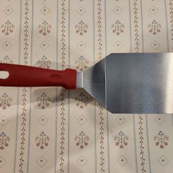 heavy-duty stainless steel turner/spatula with a red heat-resistant handle, 12"x4", good condition, 