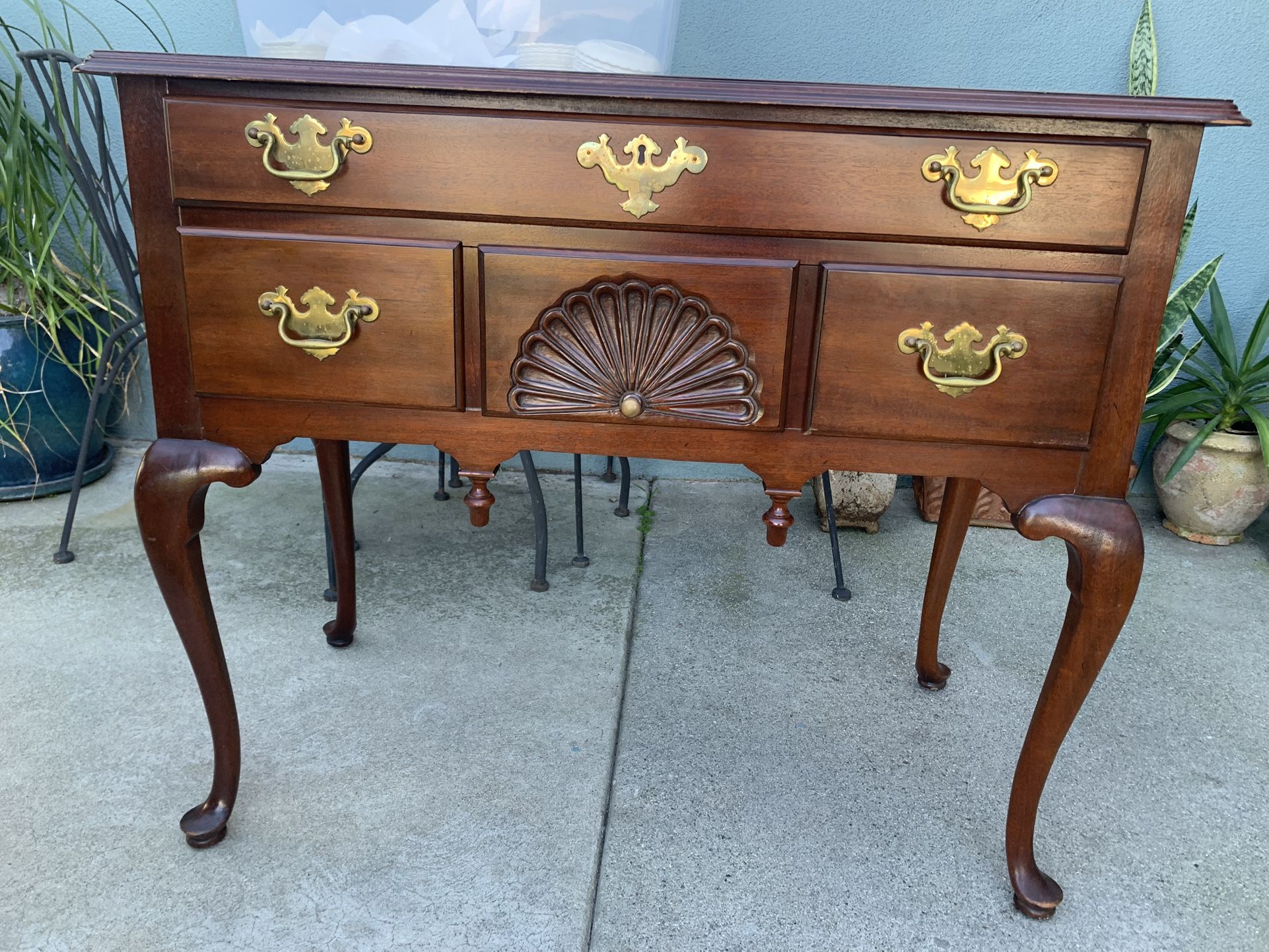 Mahogany lowboy dresser with brass hardware and fan carving.