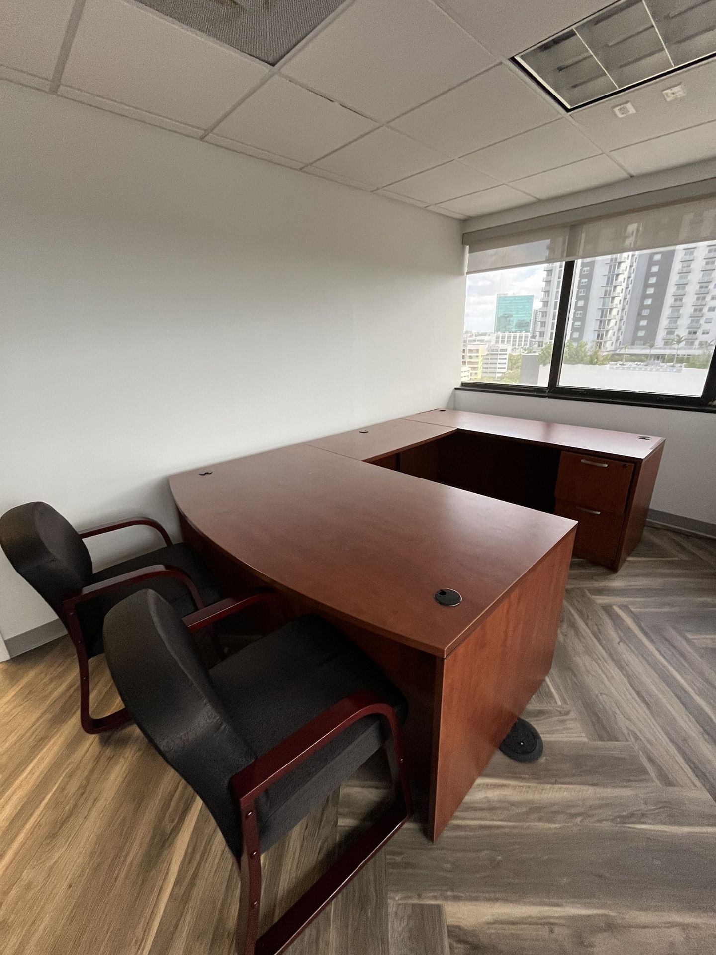 Office desk with two office chairs, and around office table