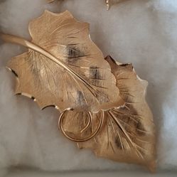 Elegant gold tone double leaf design brooch.