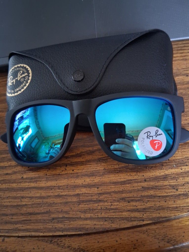 RAY BAN JUSTIN'S WITH BLACK RUBBERIZED FRAME AND BLUE MIRROR LENSES.